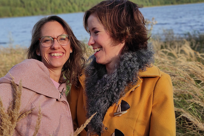 Katrin und Franziska lachend und umarmend vor einem See