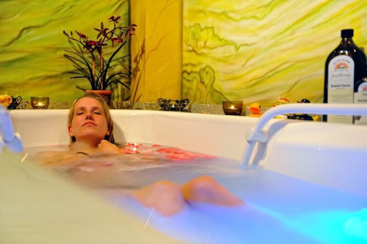 Eine Frau liegt entspannt in der Wellness-Badewanne des Landhotel Talblick.
